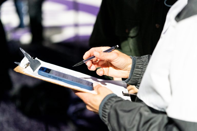 A person holding a clipboard and pencil